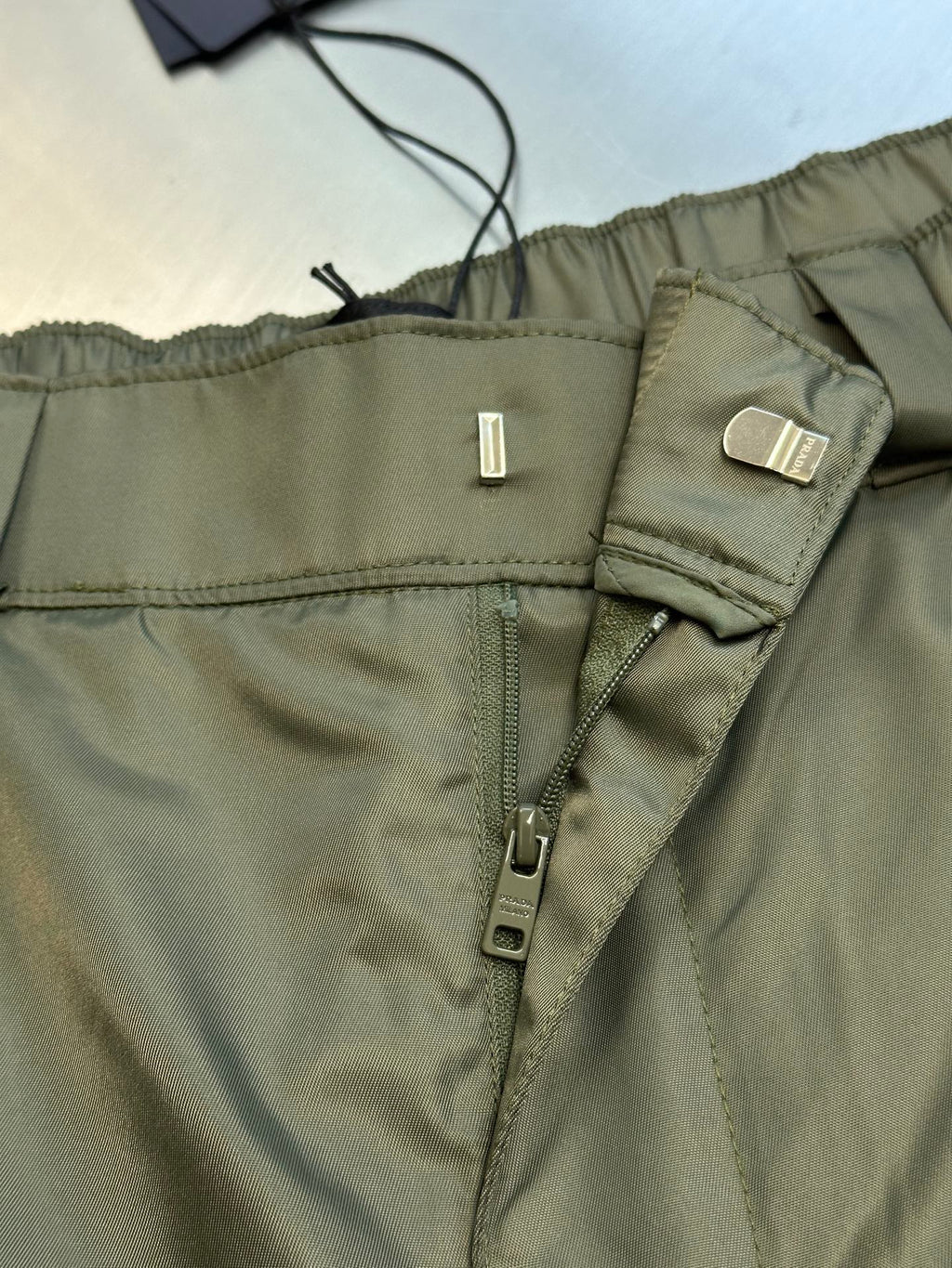 Prada cargo shorts close-up of waistband with drawstring and zipper fly hardware