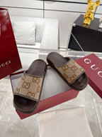 Gucci GG canvas slide sandals with tan pattern straps and dark soles