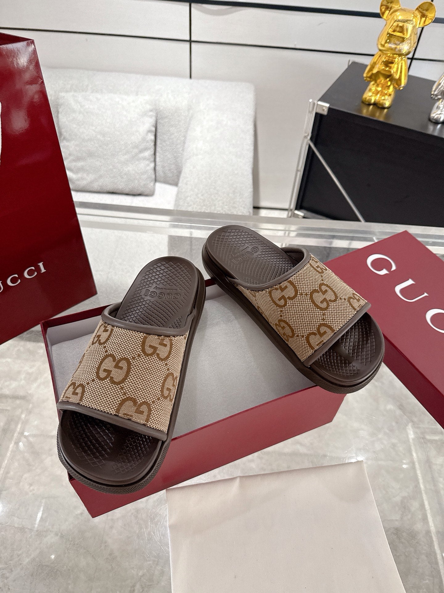 Gucci GG canvas slide sandals with tan pattern straps and dark soles