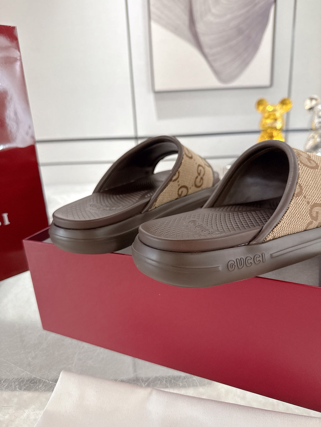 Gucci slide sandals with GG canvas uppers and dark rubber footbed
