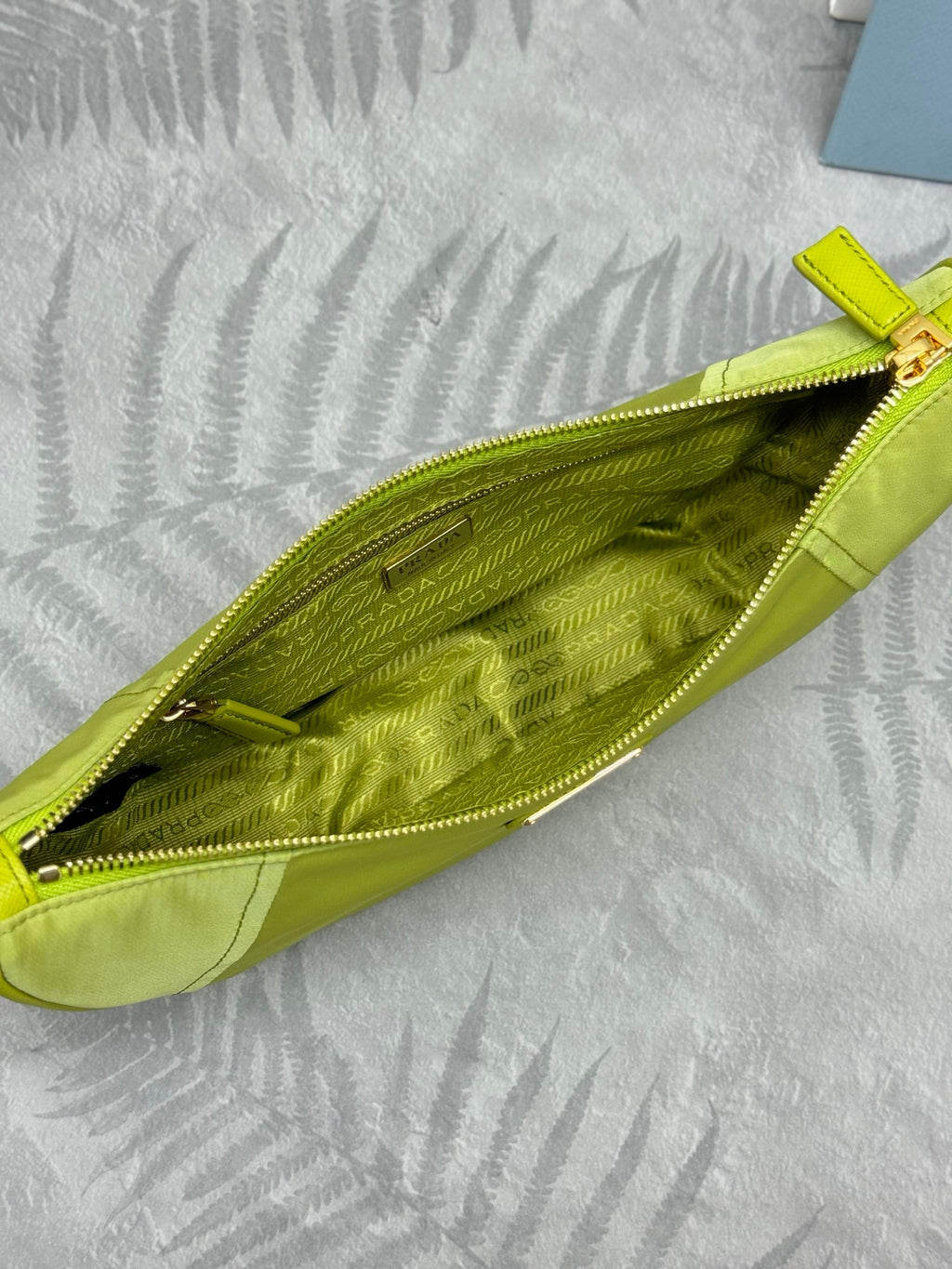 Lime green crescent shoulder bag interior shown through open top zip