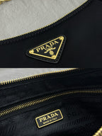 Prada dark navy logo patch on bag near gold zipper pull and gold-trim lining