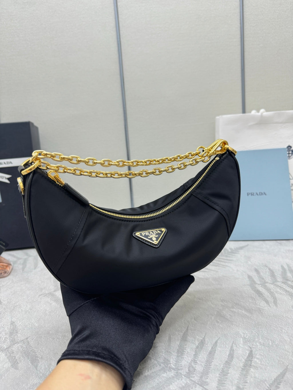 Prada crescent hobo bag in dark navy with gold chain handle strap and zip pocket