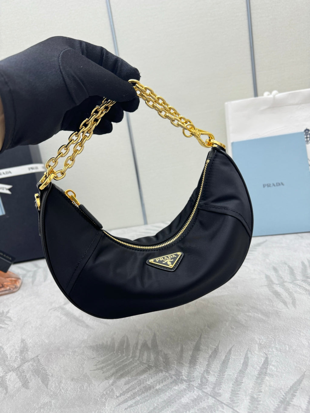 Prada crescent hobo bag in dark navy with gold chain and triangular logo patch