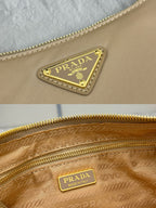 Beige Prada bag with triangular logo plaque and gold zip lining label