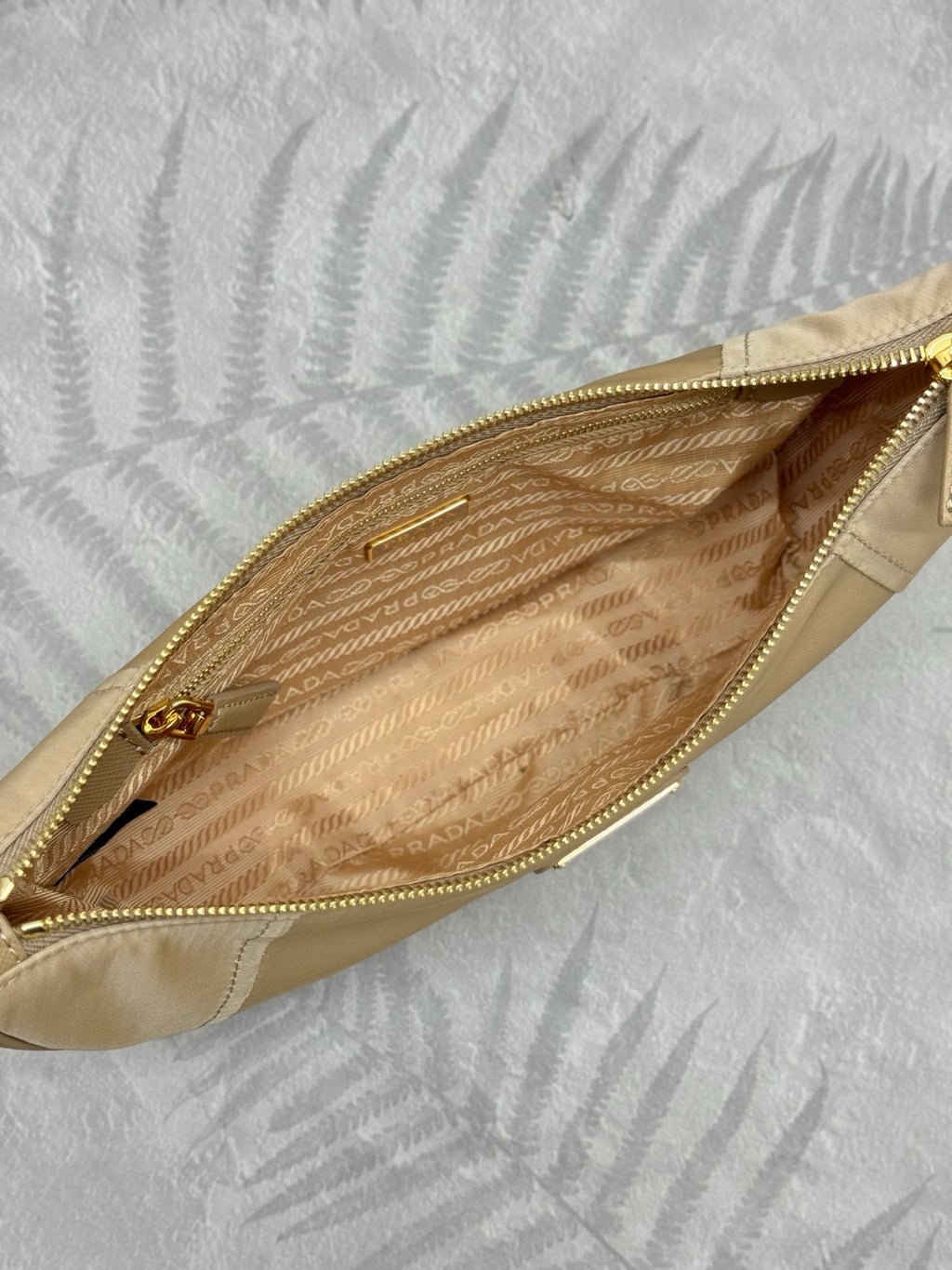 Beige shoulder bag interior view with zip opening and patterned lining