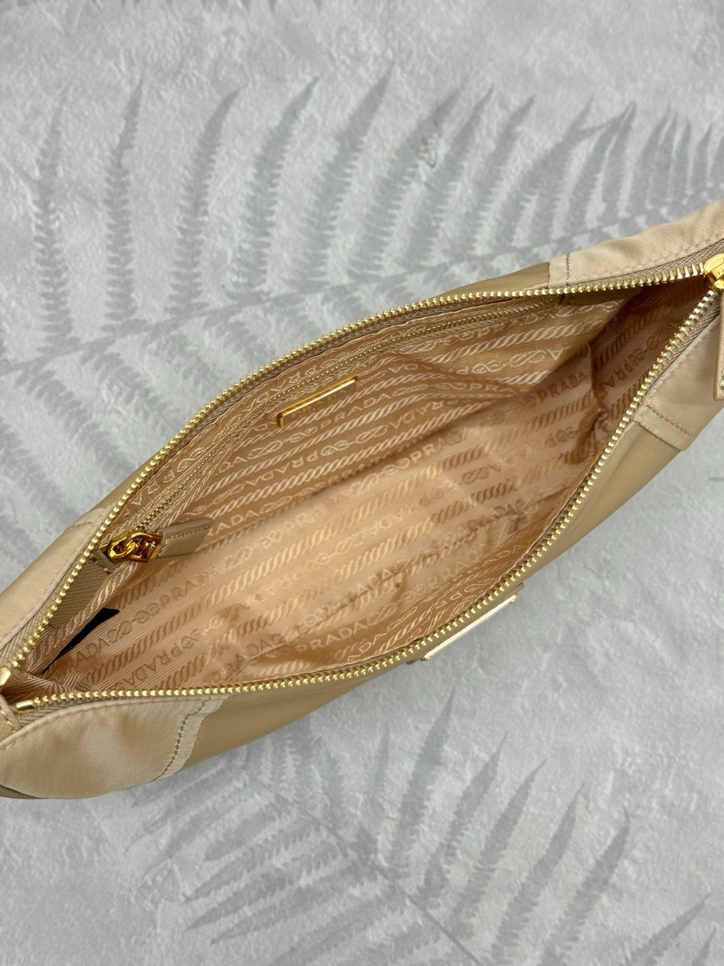 Beige shoulder bag interior view with zip opening and patterned lining