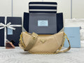 Beige shoulder bag with gold chain strap, triangular logo plaque, and zip top