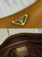 Prada tan bag close-up: gold crest logo patch and patterned lining near zipper.