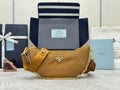 Prada hobo bag in tan leather with gold chain strap and front logo plaque.