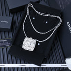 Silver-tone rhinestone square pendant necklace with twisted chain on display card