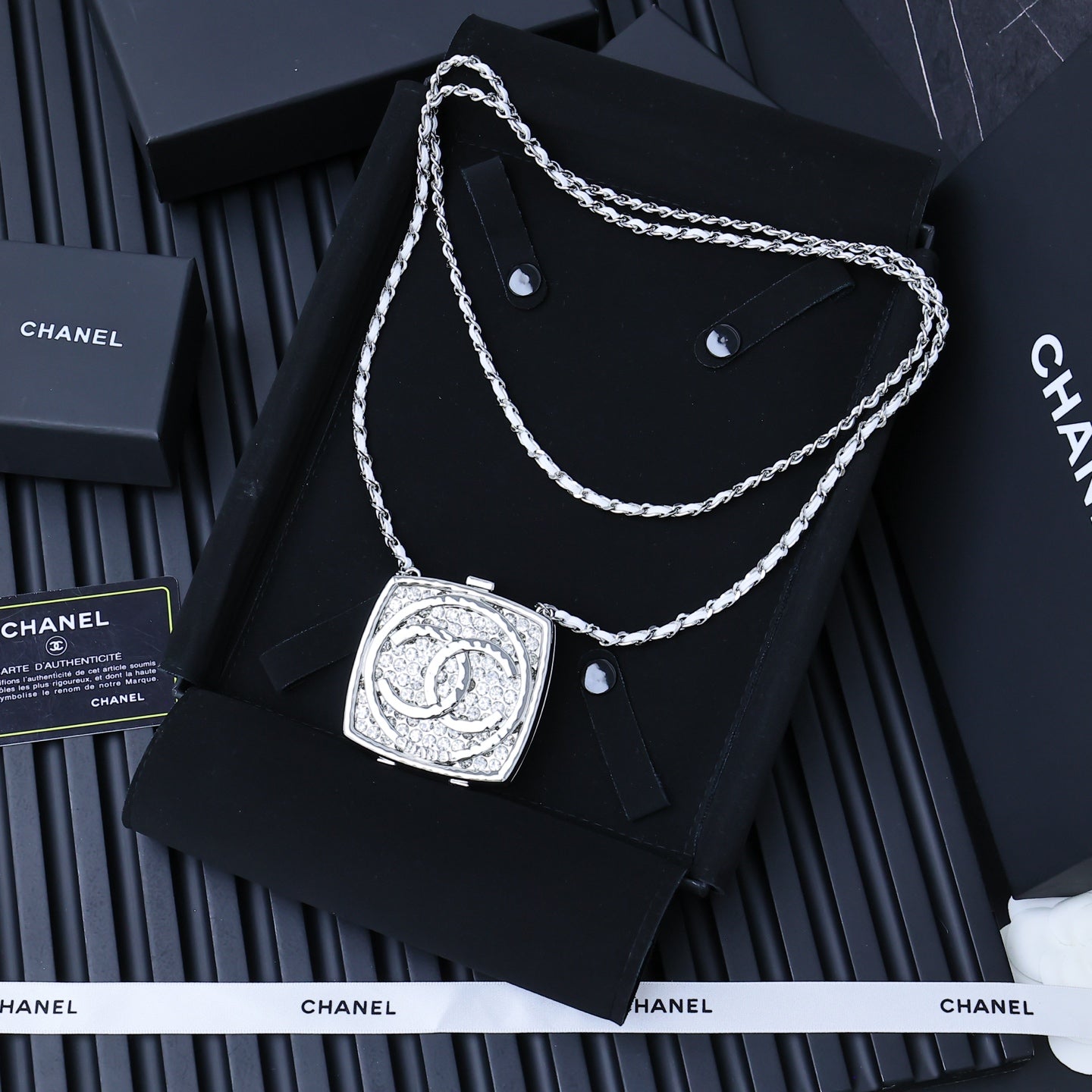 Silver-tone rhinestone square pendant necklace with twisted chain on display card