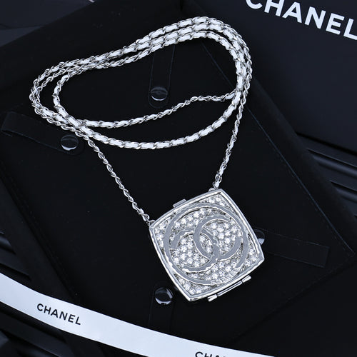 Silver-tone rhinestone square pendant necklace with braided chain and logo tag