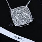 Silver-tone rhinestone square pendant necklace with ornate circular emblem