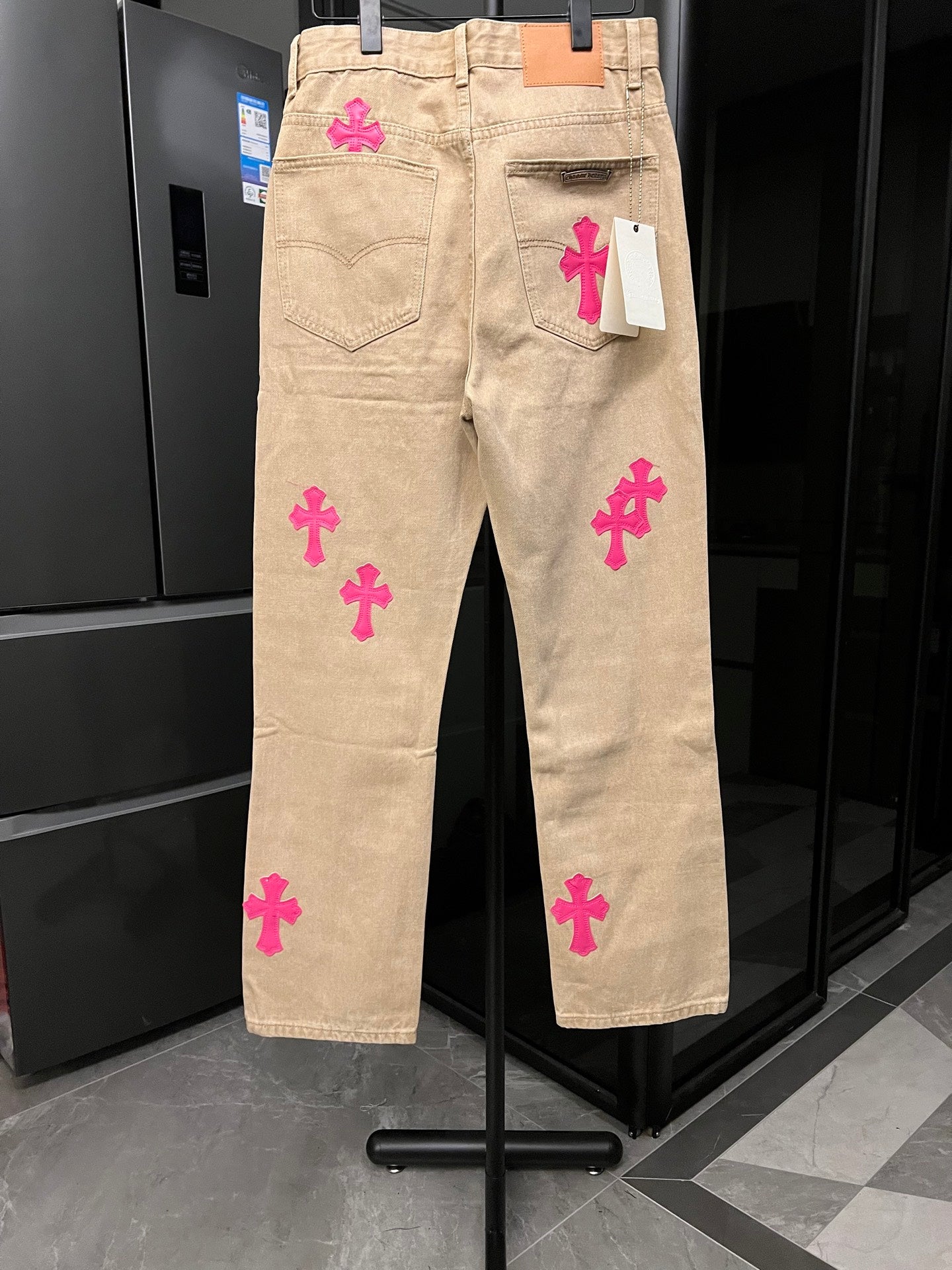 Beige denim pants with pink cross embroidery and heart-size back patch