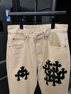 Beige denim pants with black cross patches at thighs and front pockets