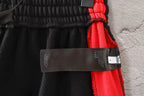 Black pants with elastic waist and red drawstring detail, hanging label