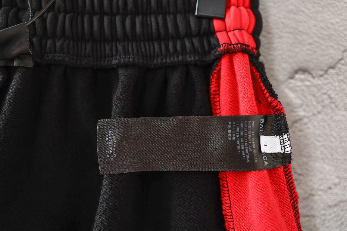 Black pants with elastic waist and red drawstring detail, hanging label