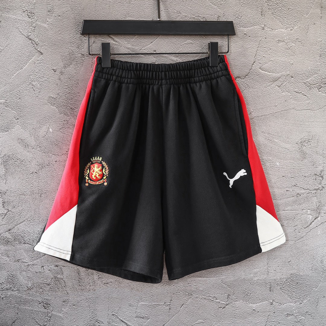Balenciaga pants with black body, red side panels, and white hem trim