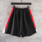 Black pants with red side panels, white trim, and elastic waistband