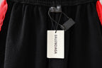 Black pants with elastic waistband and brand tags attached to the hanger