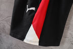 Black pants with white and red side stripe details at the hem