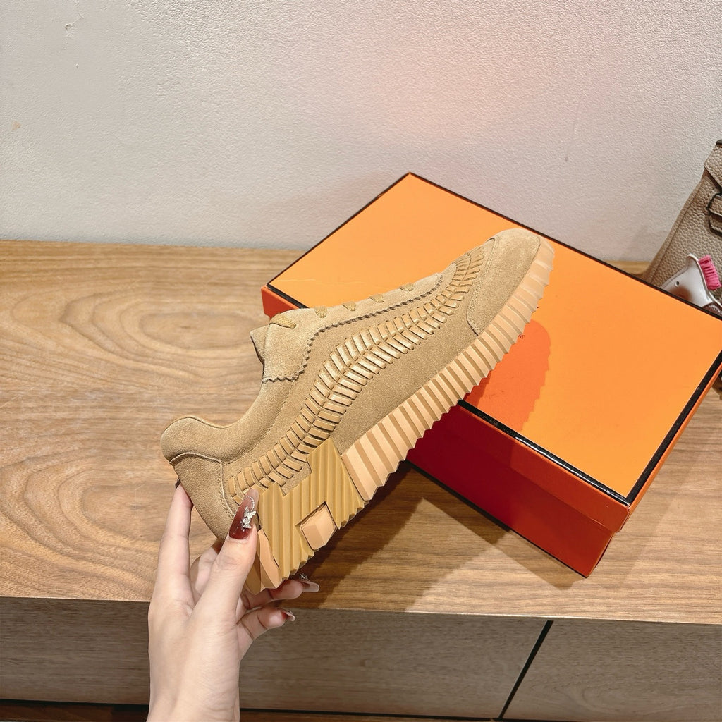 Beige Hermes unisex sneakers on orange box, lace-up with textured side stripes