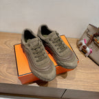 Olive suede lace-up sneakers on orange box, front view