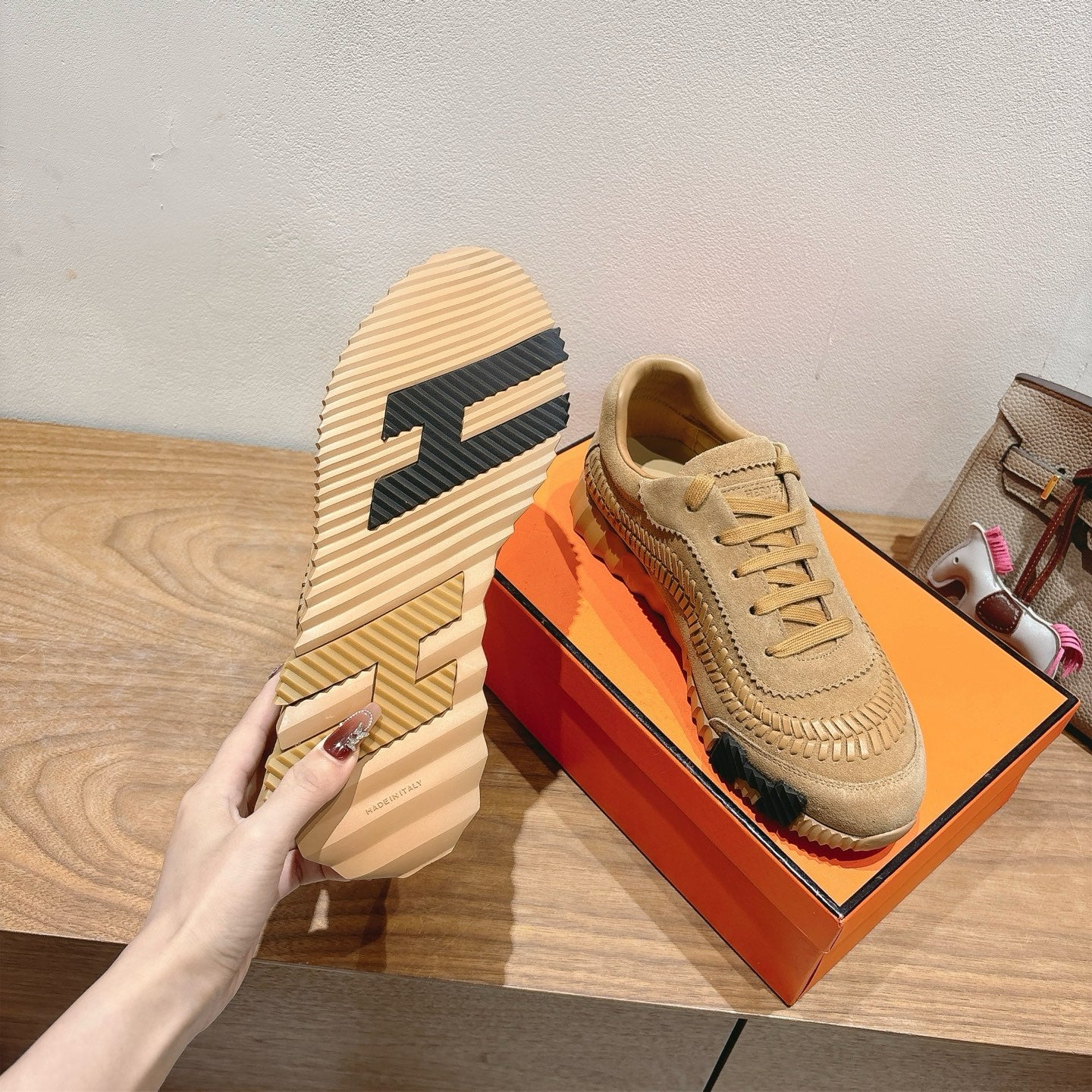 Beige Hermes unisex sneakers with bold patterned heel and lace-up design