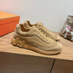 Beige Hermes unisex sneakers with lace-up, layered stitching, and chunky sole
