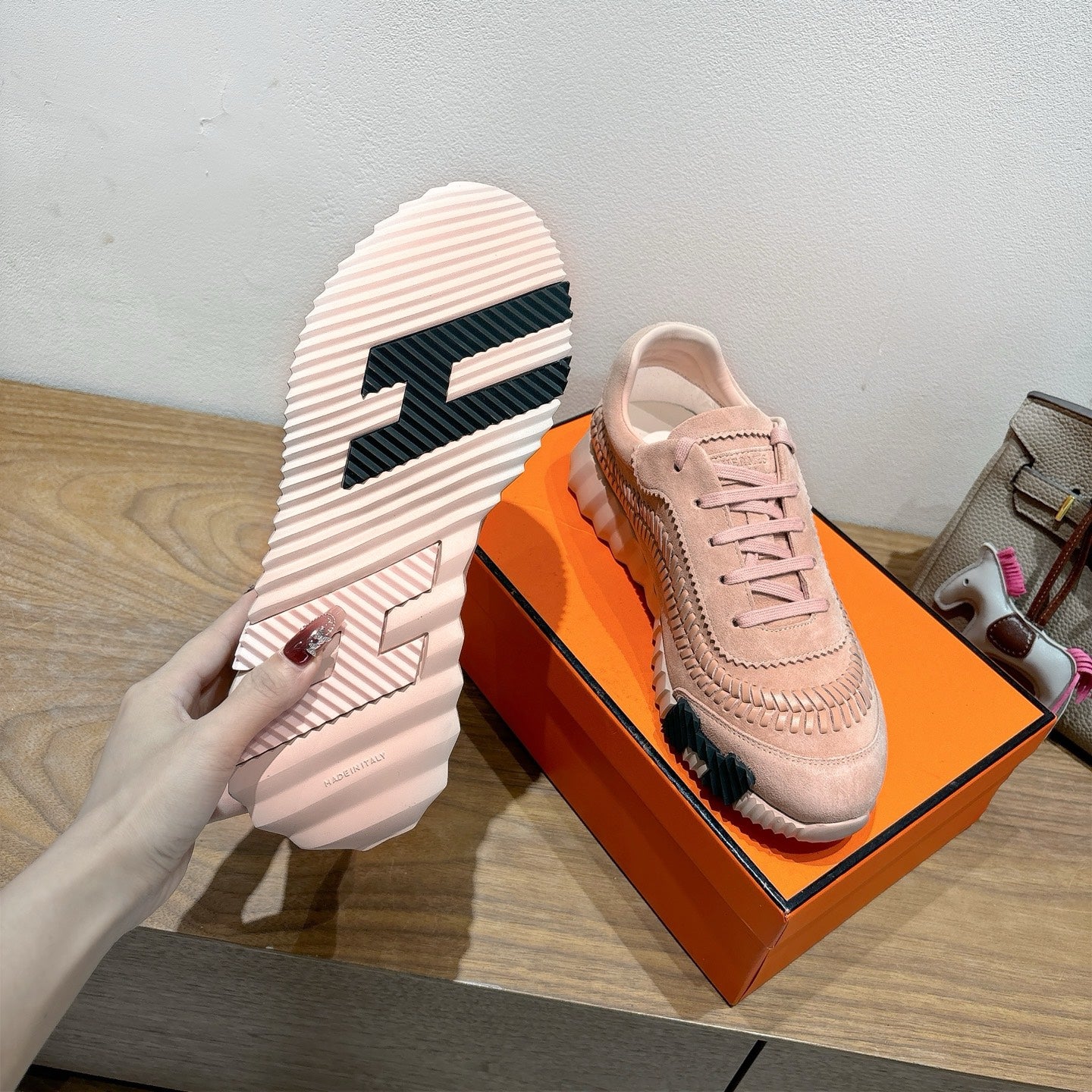 Hermes light pink sneakers with striped outsole viewed from the bottom