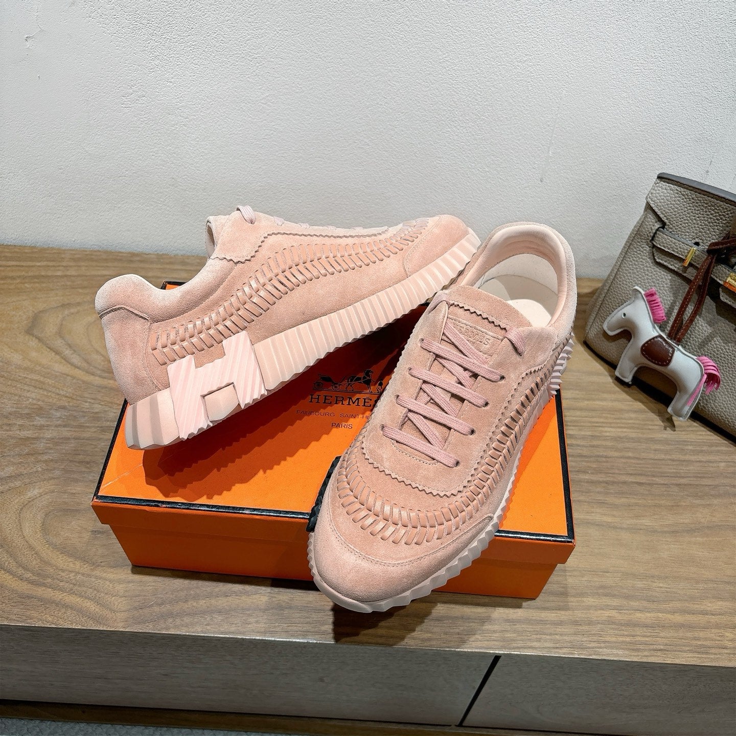 Hermes light pink lace-up sneakers on orange box, suede upper with ridged sole