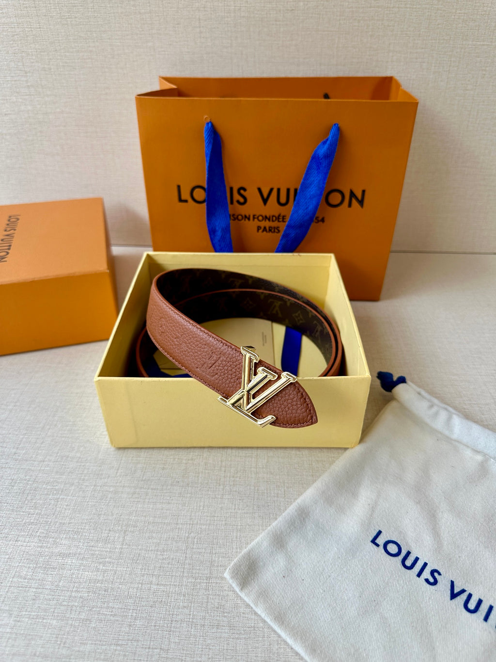 Louis Vuitton belt in box with brown leather strap and LV silver-tone buckle.