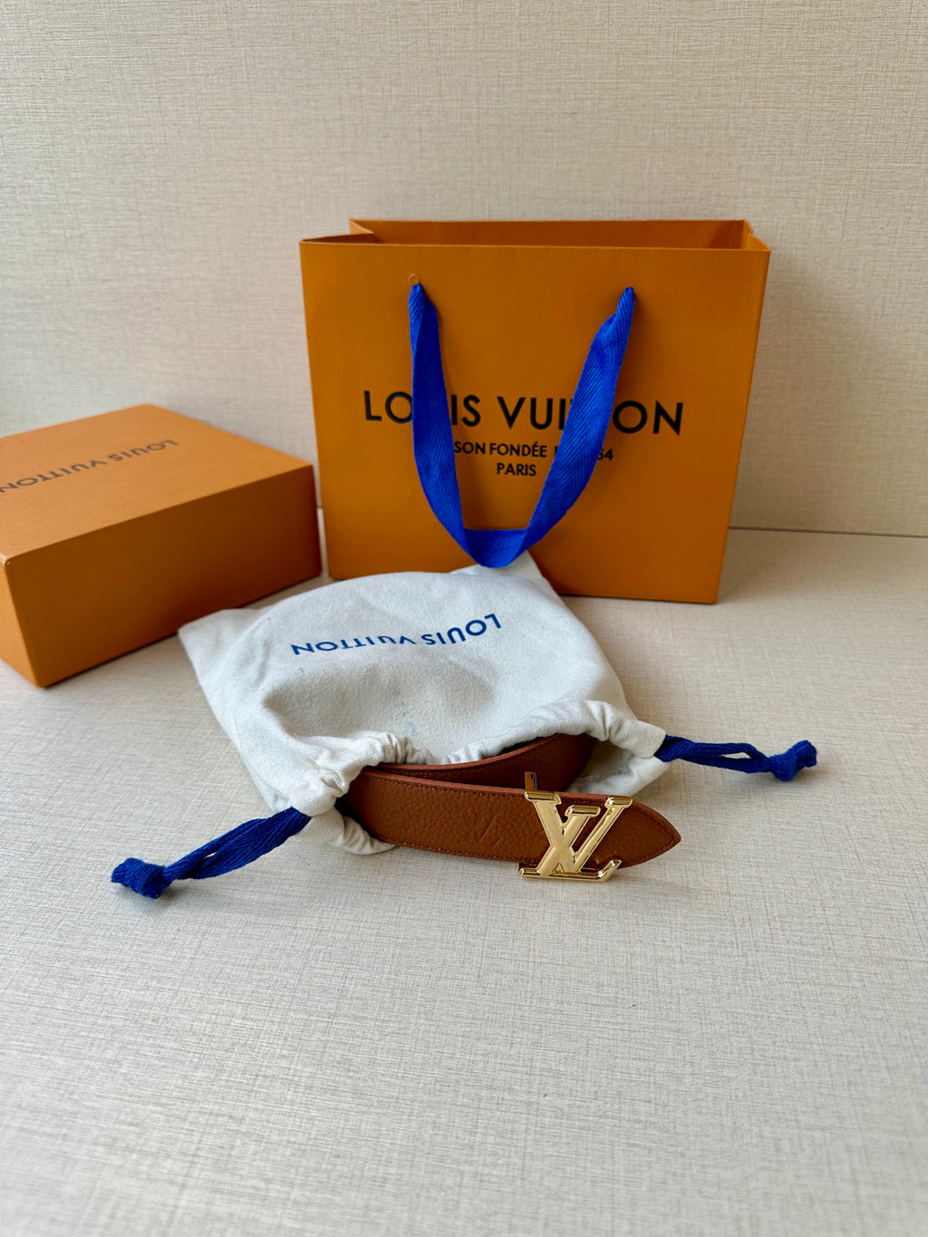 Louis Vuitton belt with brown leather strap and LV silver-tone buckle, in cloth pouch.