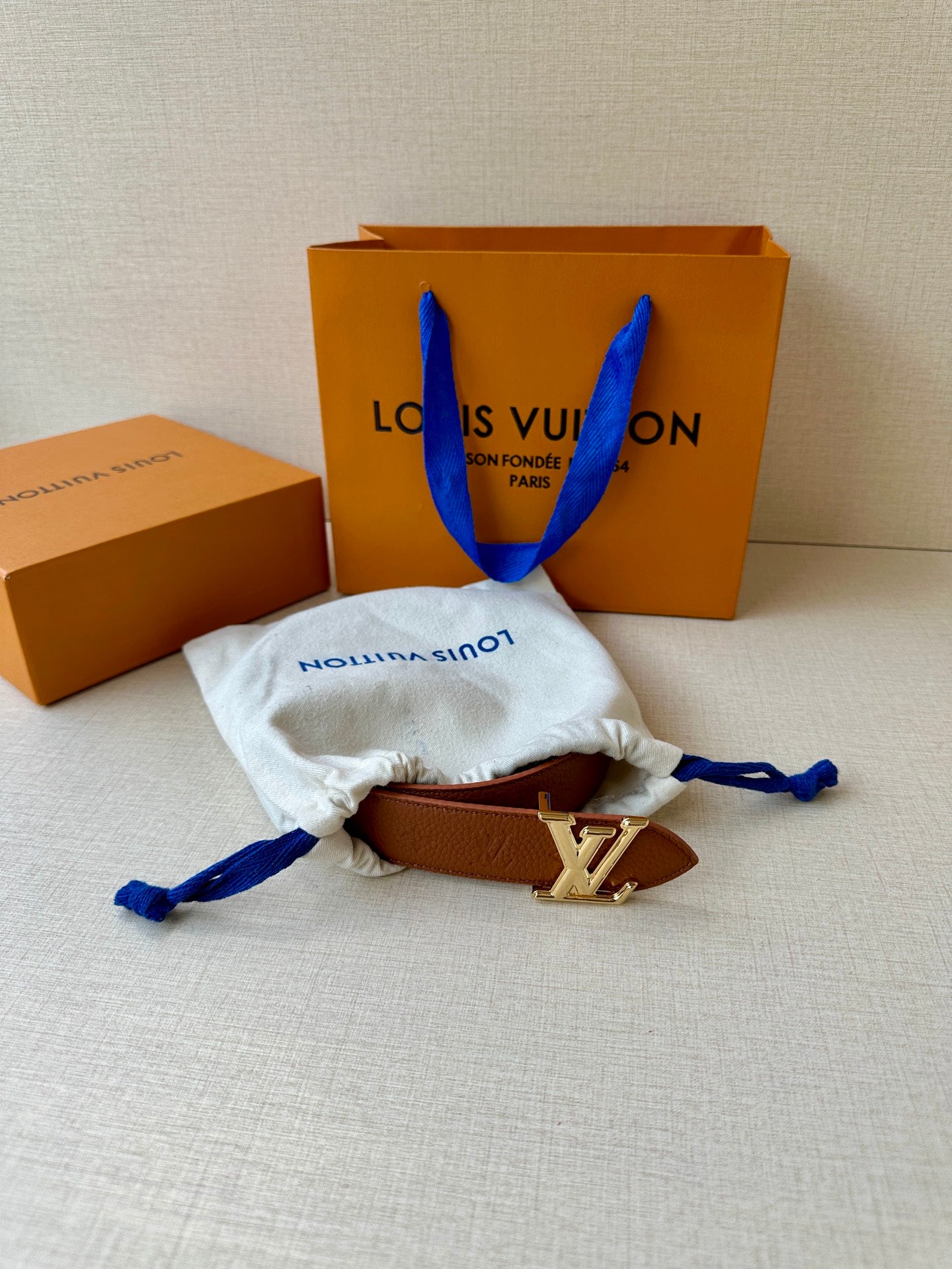 Louis Vuitton belt with brown leather strap and LV silver-tone buckle, in cloth pouch.