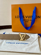 Beige monogram belt with gold-tone LV buckle centered on strap