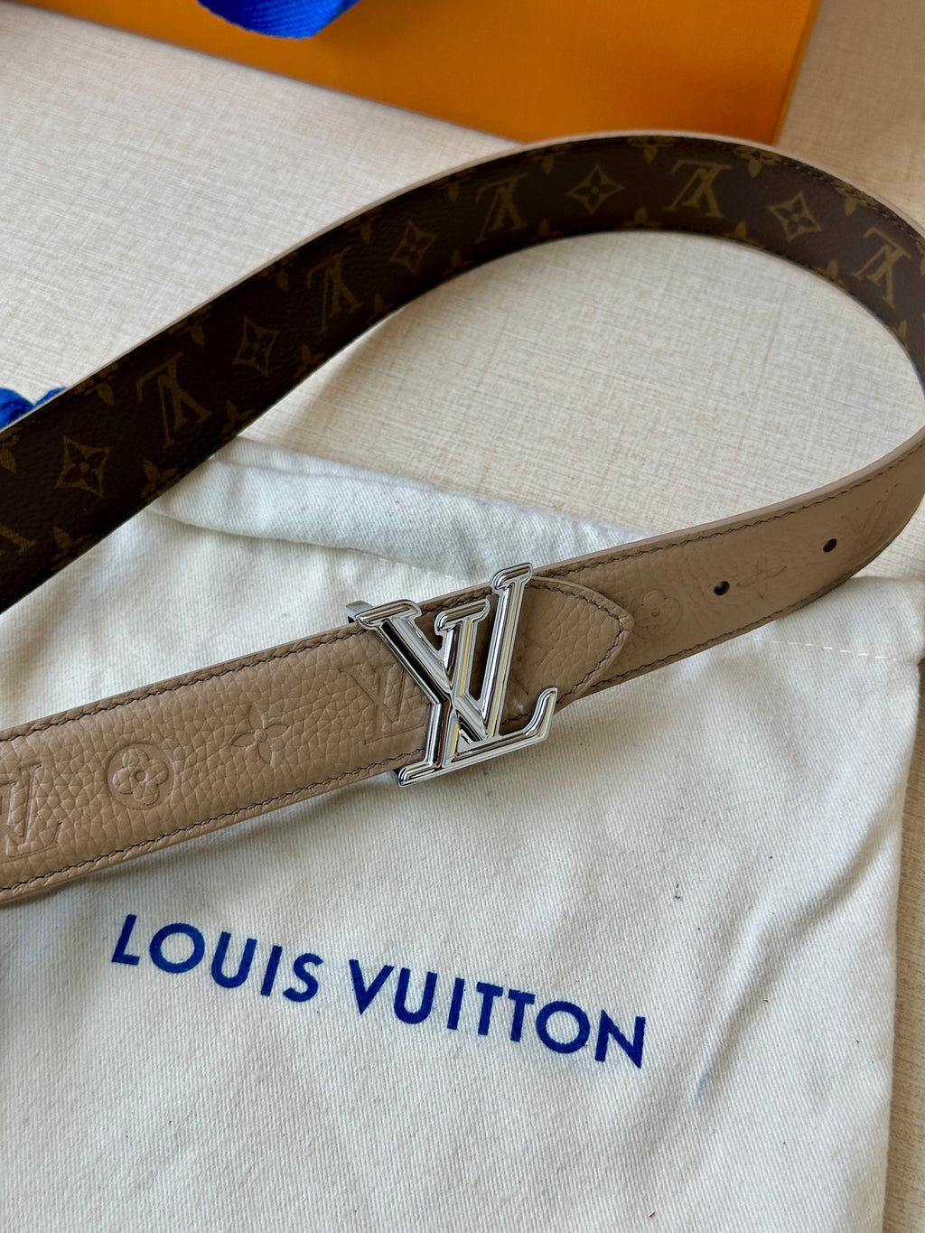 Beige monogram belt with silver-tone LV buckle and punched holes