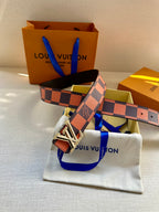 Orange and navy checker belt with silver buckle shown with gift packaging