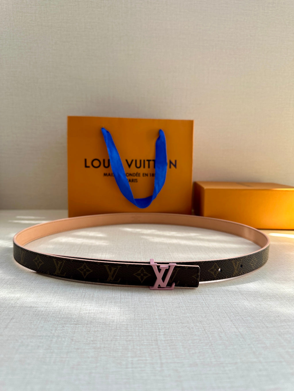 Louis Vuitton monogram belt with tan strap and pink LV buckle