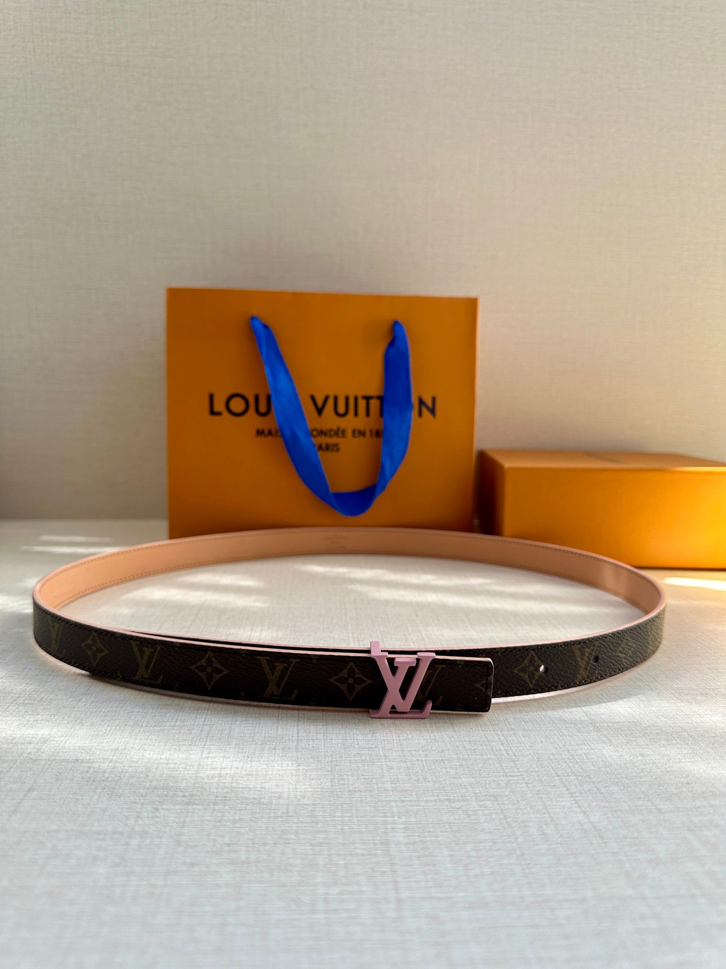 Louis Vuitton monogram belt with tan strap and pink LV buckle