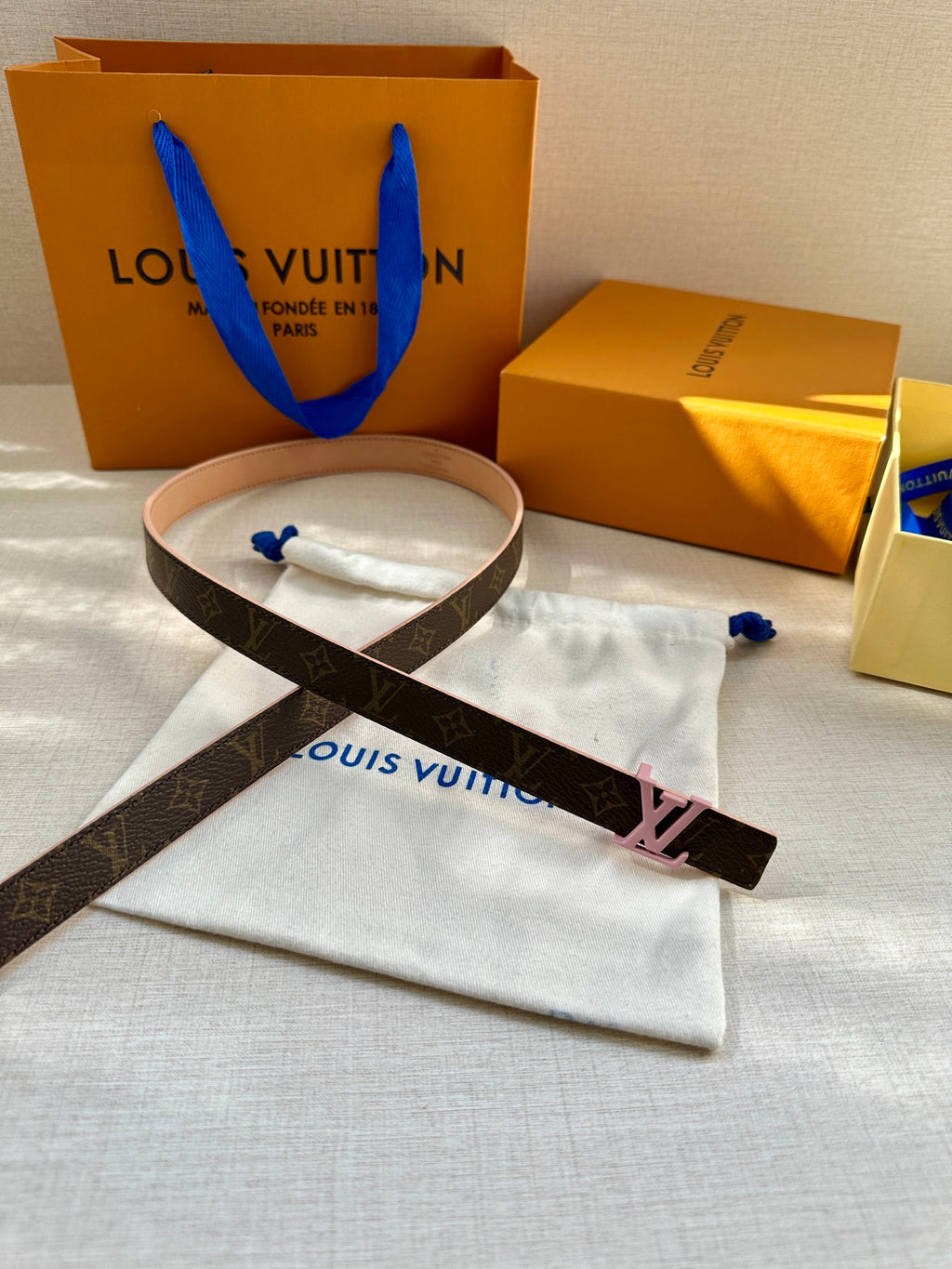 Louis Vuitton monogram belt with pink LV buckle and tan leather strap
