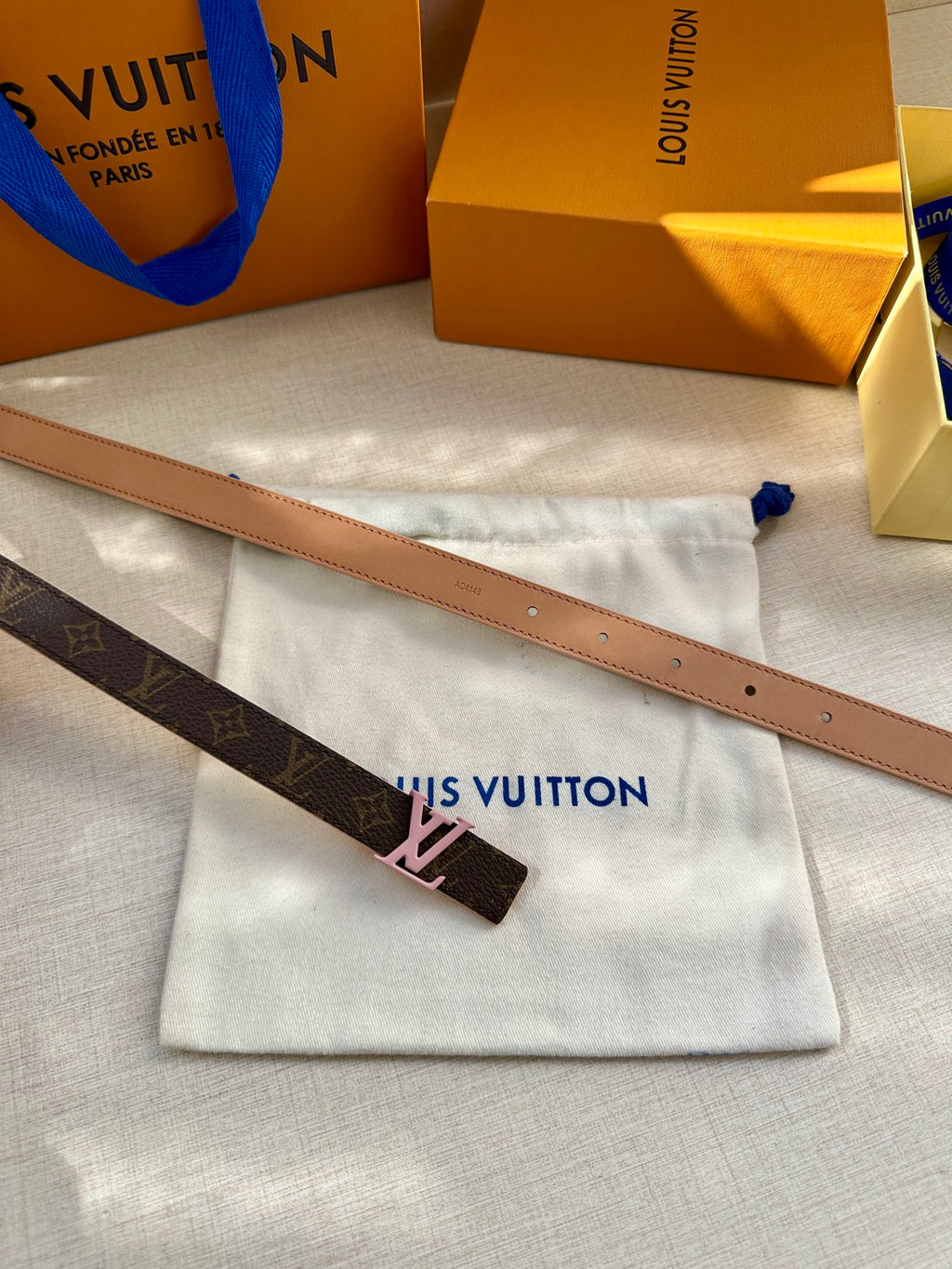 Louis Vuitton monogram belt with pink LV buckle and tan edge detail
