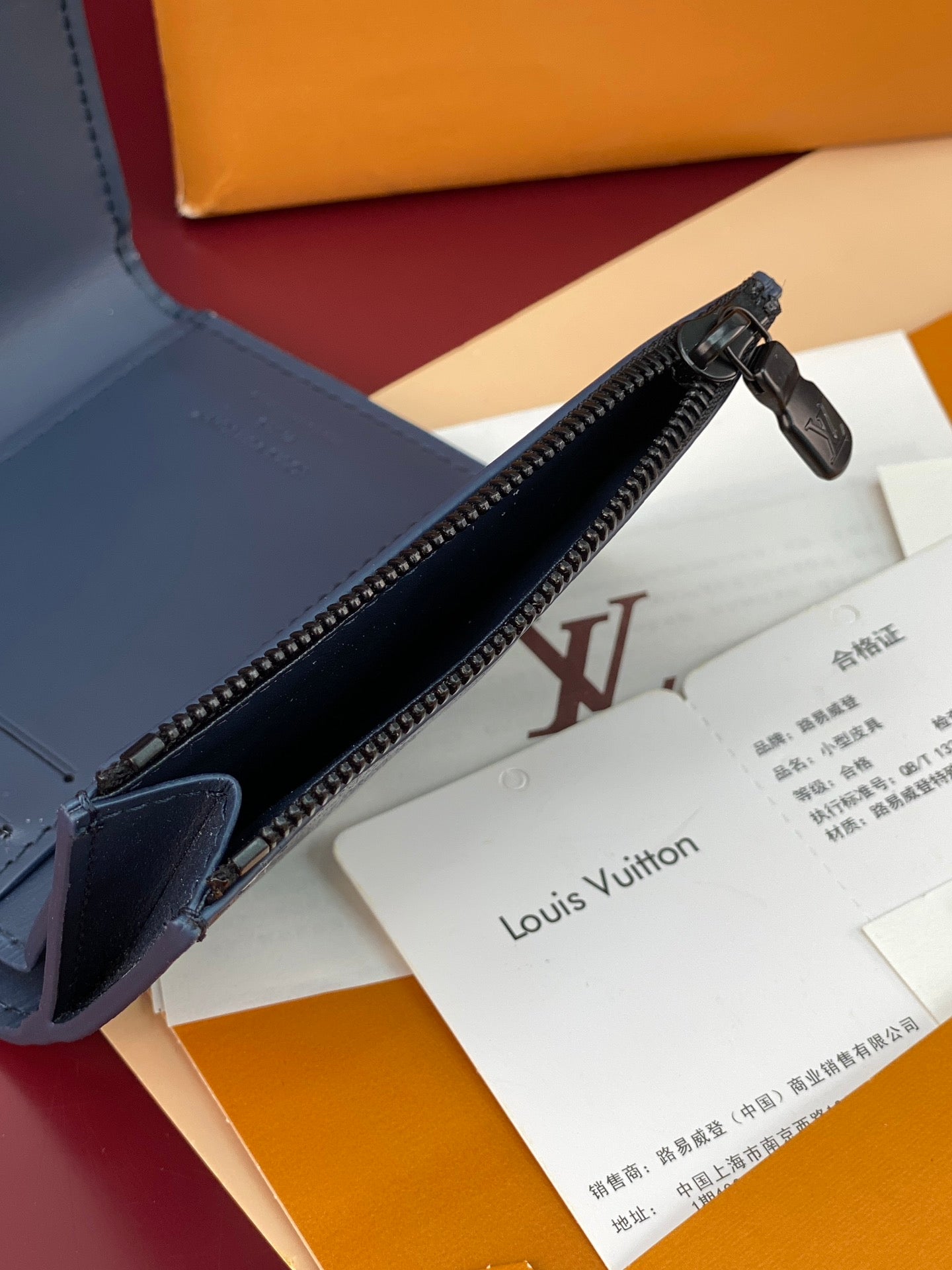 Blue zip-around wallet edge with metal zipper and interior lining, partially open