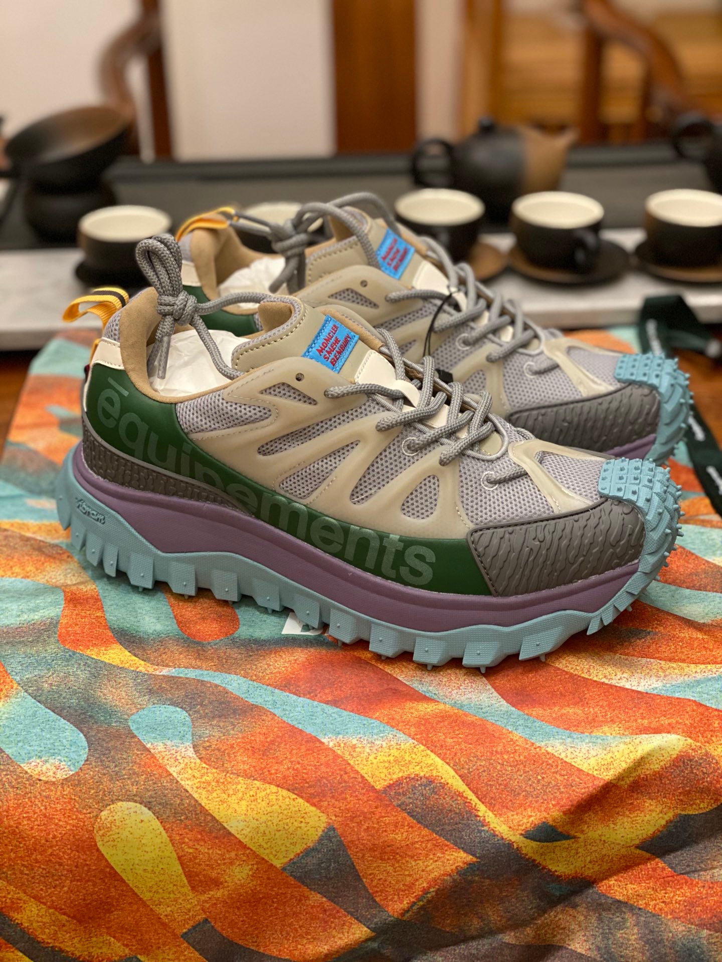 Light gray sneakers with olive band, purple midsole, turquoise treaded outsole