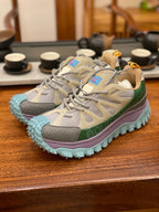 Pair of light gray sneakers with olive details and purple-turquoise chunky soles