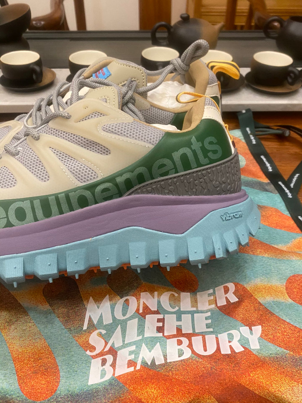 Light gray sneakers with olive accents and purple midsole, turquoise outsole close-up