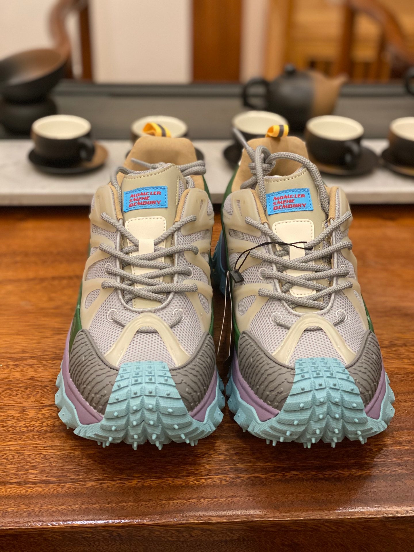 Light gray sneakers with olive panels, purple midsole, turquoise tread sole, back view