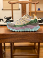 Light gray sneakers with olive and purple accents, turquoise chunky outsole