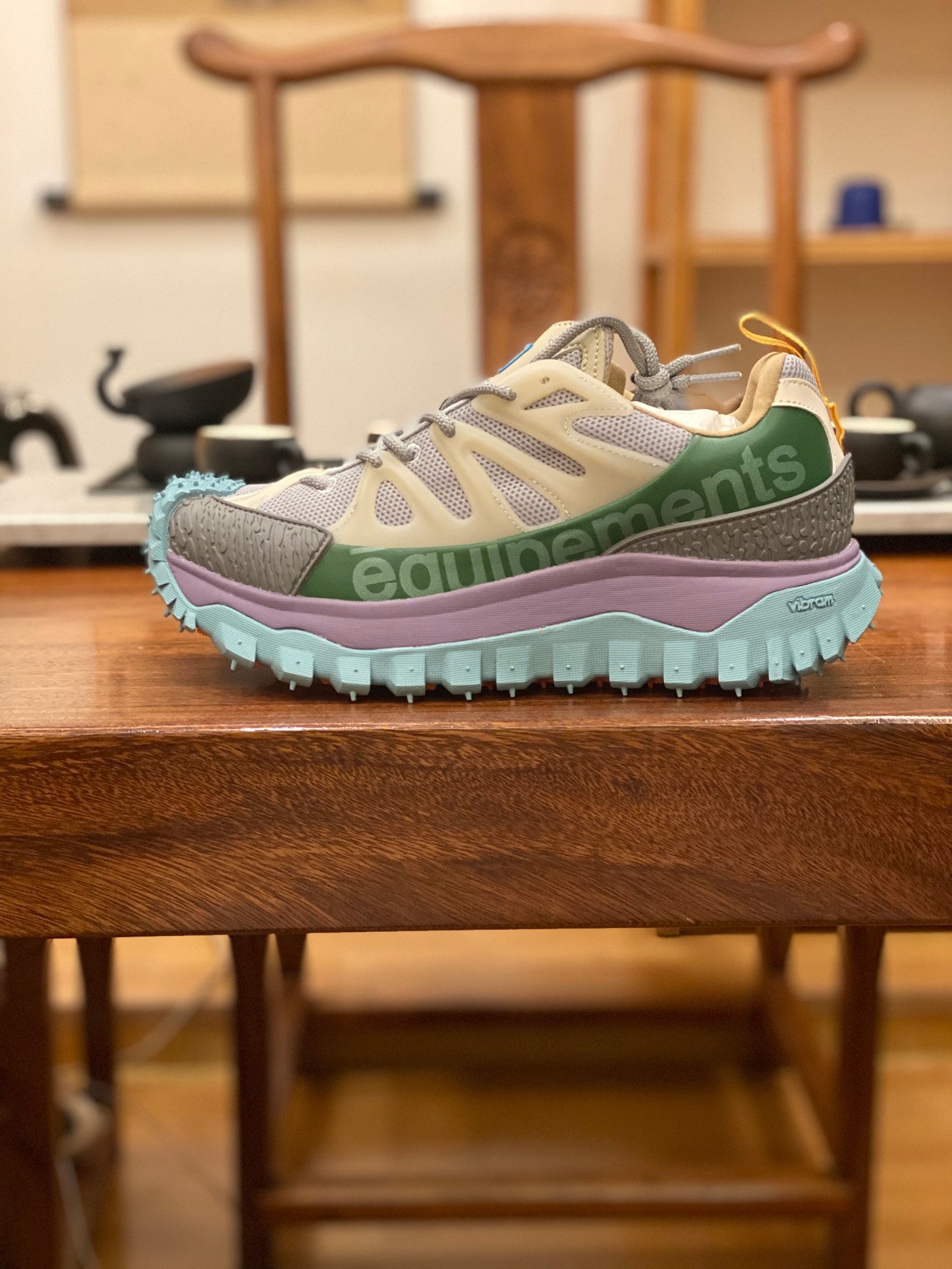 Light gray sneakers with olive and purple accents, turquoise chunky outsole