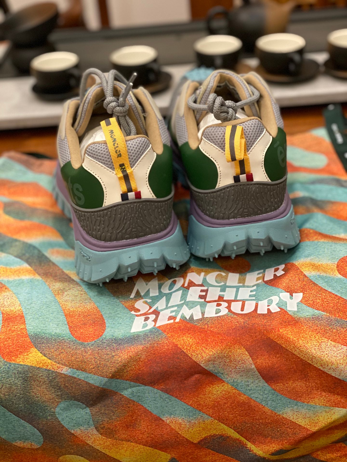 Back view of light gray sneakers with olive panels and purple midsole, turquoise soles